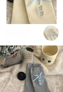 Detail von Strickstrümpfen mit blauen Schleifen und bestickten Herzen für Damen