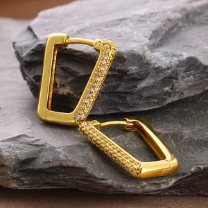 Macro view of 18k gold plated rectangular earrings with white cubic zirconia on stone