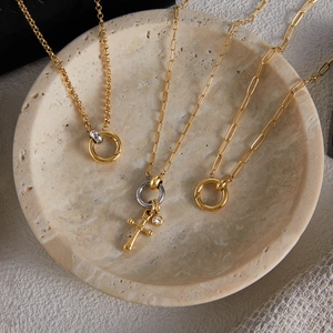 Classic 18K gold and silver two-tone stainless steel chain necklaces in a marble bowl