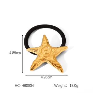 Macro shot of gold starfish hair tie with hammered metal texture and 4.96cm dimensions