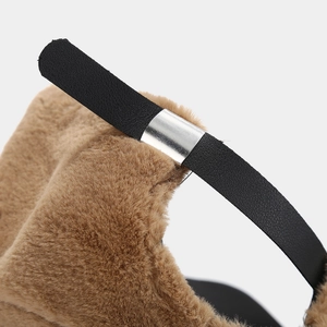 Detail view of plush brown faux fur texture and black leather strap with silver buckle