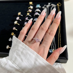 Close-up of a pink heart-shaped gemstone ring with micro-pave diamonds on model finger