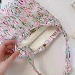 Detail of floral jacquard fabric with bronze magnetic buckle and canvas lining inside