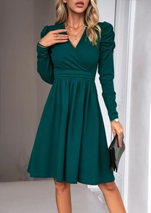 Detail view of dark green V-neck dress featuring puff sleeves and pleated waist design