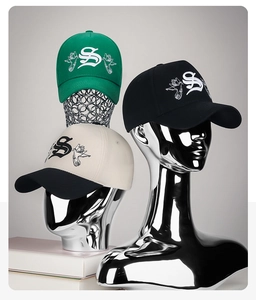 Detailed embroidery of gothic letter S and bird on cotton canvas baseball caps