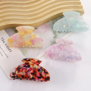 Set of four colorful acetate hair claws with marble and floral patterns for women