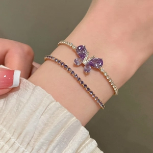 Gros plan d'un ensemble de bracelets papillon dorés avec cristaux de zircon violets