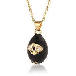 Macro shot of evil eye pendant with black enamel and gold finish on delicate chain