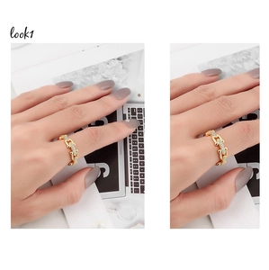 Close-up of gold chain-link open ring with sparkling crystals on a lifestyle background