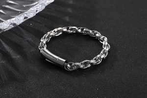 Detail view of silver stainless steel chain bracelet with cylindrical magnetic clasp on black