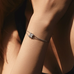 Silver double-layer clover bracelet with sparkling crystals on model's wrist