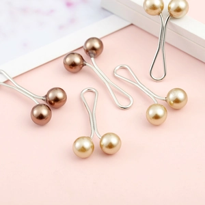 Detailed view of metal U-shaped clips with champagne and brown pearls for scarf styling
