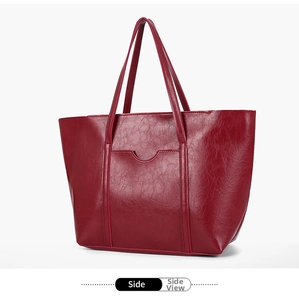Side view detail of a dark red oil wax leather tote bag with a smooth vintage texture