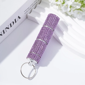 Macro detail of purple rhinestone pill bottle with three sections and silver keychain ring
