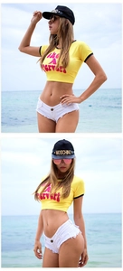 Dettaglio del crop top giallo in maglia e shorts di jeans bianchi sulla spiaggia