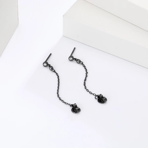 Détail de boucles d'oreilles S925 argent noir avec pompons, zircon et fermoir papillon