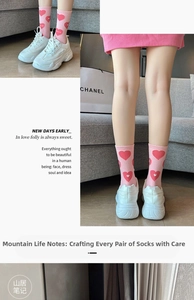 Detailed view of pink cotton crew socks featuring red heart patterns and letter embroidery
