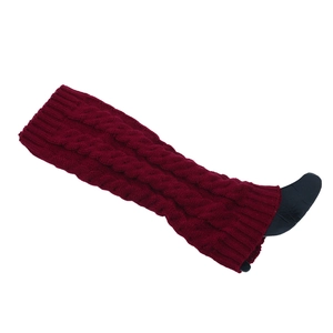 Macro detail of thick dark red cable knit leg warmers showing textured wool pattern