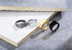 Detailed view of rectangular stainless steel signet rings in gold, silver, and black finishes