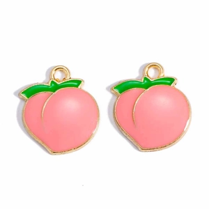 Detail of pink enamel peach charms with golden borders and green leaves for DIY jewelry