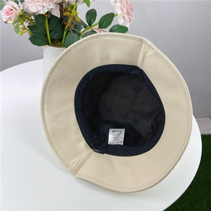 Detail view of the inner lining and fabric care label on a beige flower bucket hat