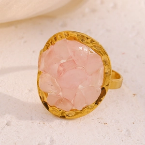 Macro di anello placcato oro 18K con pietre rosa tritate e dettaglio di trama martellata