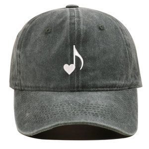 Close-up of heart and music note embroidery on a dark grey washed cotton baseball cap