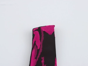 Detailed close-up of jacquard fabric featuring fuchsia patterns on a black background