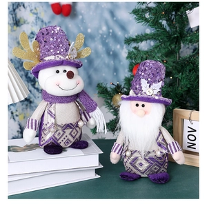 Detail of purple sequin Santa gnome and reindeer doll set on a festive winter table