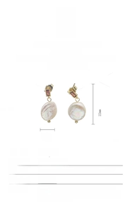 Detailed view of baroque pearl earrings with red gemstone in 18K gold-plated setting