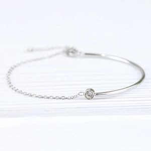 Macro view of silver stainless steel chain bracelet featuring a polished bar and zircon stone