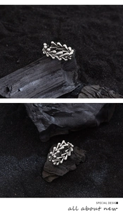 Detail of silver irregular thorn heart ring on black charcoal for a vintage aesthetic