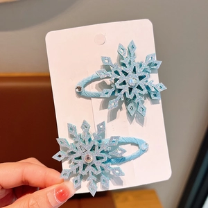 Sparkly blue snowflake hair clips for girls with glitter finish on display card
