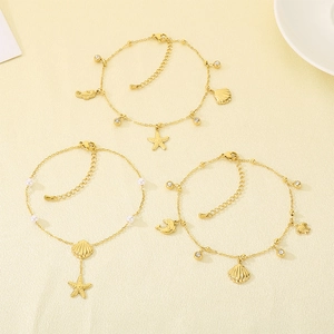 Detalle de tobilleras doradas con colgantes de estrella de mar, concha y delfín.