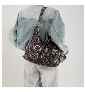 Leopard print tote bag with metal rings shown on model back view in a studio setting
