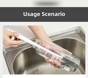 Detail view of long handle silicone brush cleaning a glass bottle in a kitchen sink