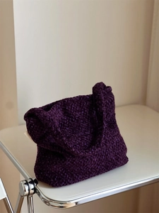 Dettaglio della borsa a spalla in tweed viola con trama spessa e tracolla larga