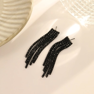 Macro detail of elegant black tassel earrings with sparkling rhinestone fringe and long drop design