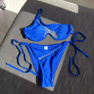 Detail of electric blue bikini featuring asymmetrical mesh cutout and side tie bottoms