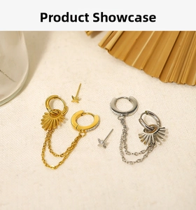 Detail of 18K gold and silver tassel chain earrings with sunburst pendant on textured background