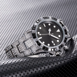 Macro shot of silver diamond-encrusted watch featuring black dial and green sunray sub-dials