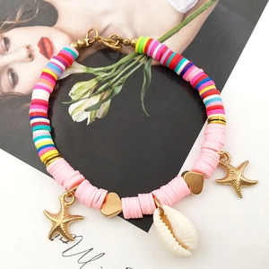 Pink and rainbow clay bead bracelet with golden heart, starfish, and white shell charms