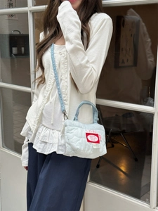 Mini borsa a tracolla trapuntata celeste con etichetta ciliegia e cinturino denim