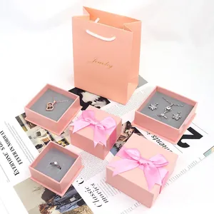 Elegant pink jewelry gift boxes and matching paper bag with ribbon bows for packaging