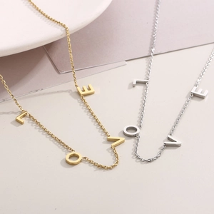 Vue détaillée des colliers LOVE en or et argent sur un fond élégant et épuré