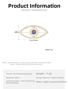 Detailed view showing dimensions of a gold evil eye brooch with white and blue rhinestones