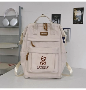 Detail view of cream school backpack featuring durable nylon fabric and stylish zippers