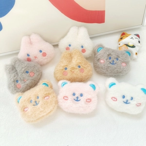 Flat lay of cute plush bunny and bear brooches in various macaron colors on a white desk