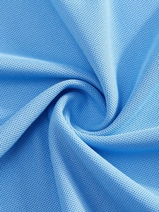Gros plan sur la texture du tissu piqué bleu respirant avec un drapé doux pour polos