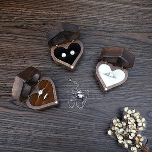 Top view of heart-shaped walnut wood jewelry box with soft lining and rings